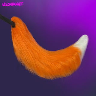 An orange faux fur fox tail with a white tip