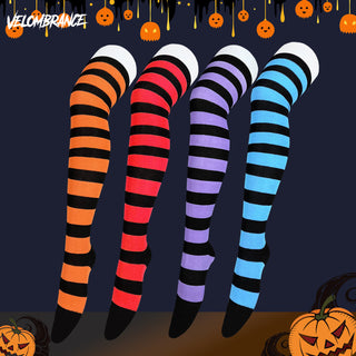 Four Halloween-themed striped leg warmers displayed on invisible mannequin legs, featuring orange and black, red and black, purple and black, and blue and black stripes. The background is dark navy blue with a Halloween theme, including pumpkins, dripping wax, and the brand name 'Velombrance' in the top left corner.