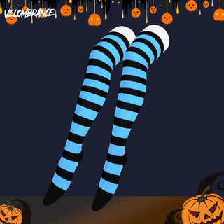 A pair of thigh-high socks with bold black and light blue horizontal stripes, shown floating against a dark navy Halloween-themed background with pumpkins and the Velombrance logo.